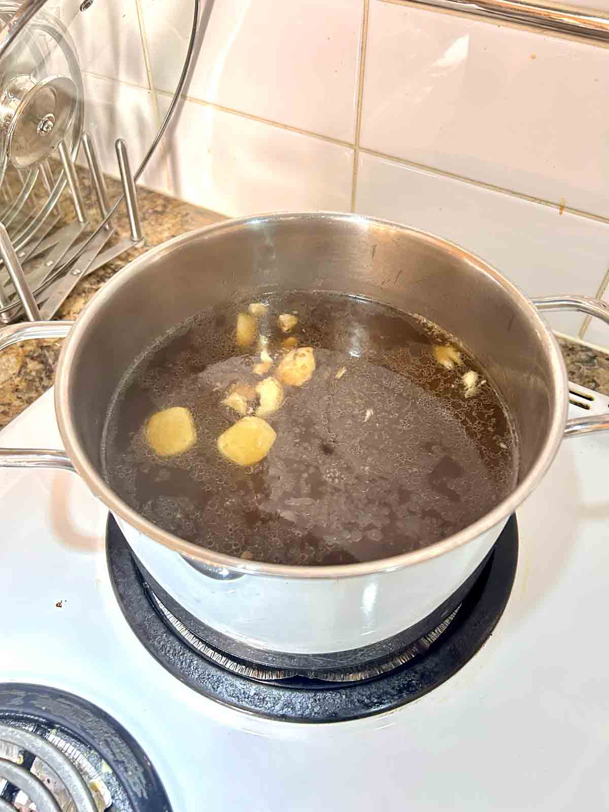 chicken broth and soy sauce added to pot.