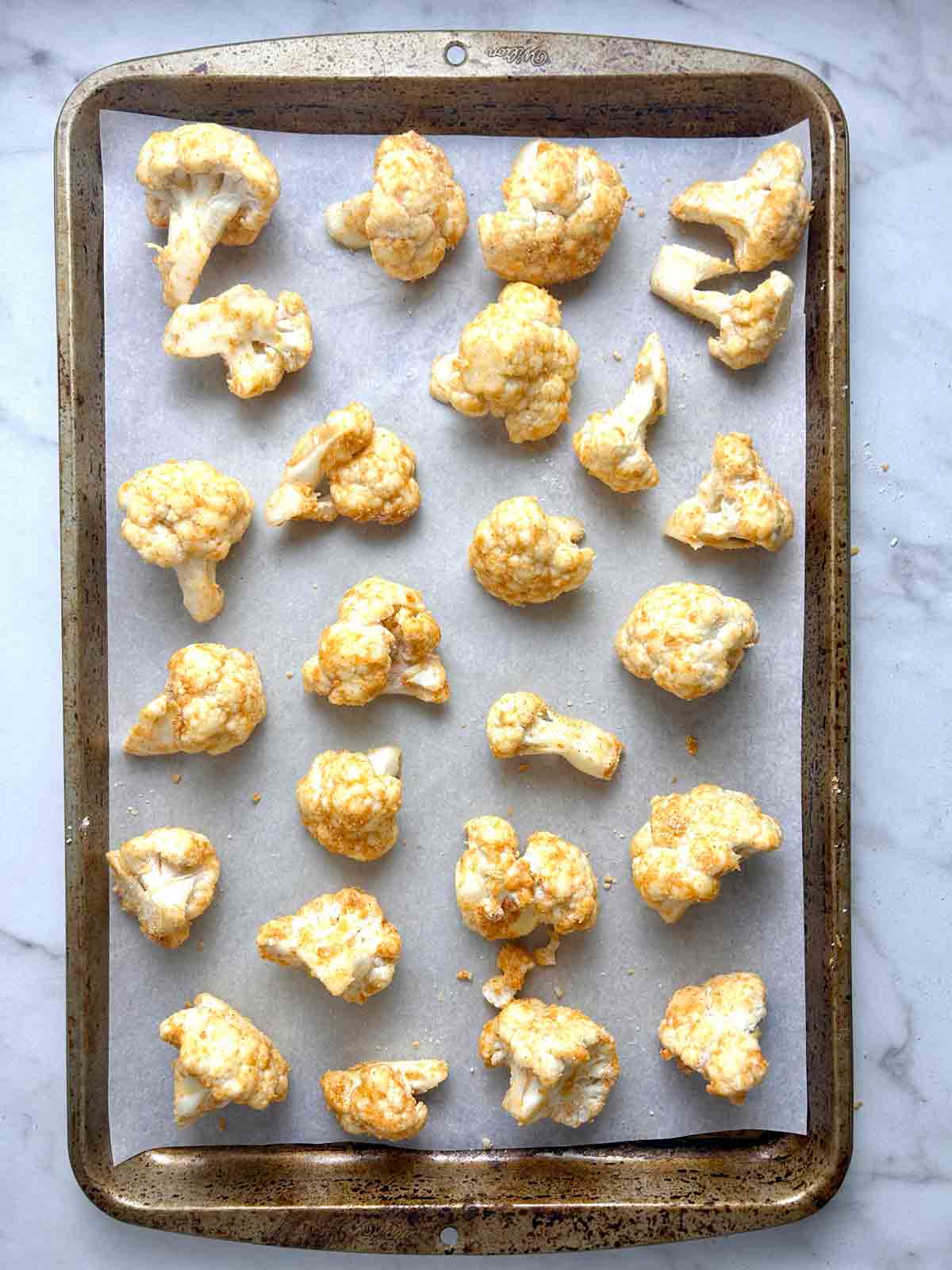 seasoned cauliflower arranged on baking sheet.