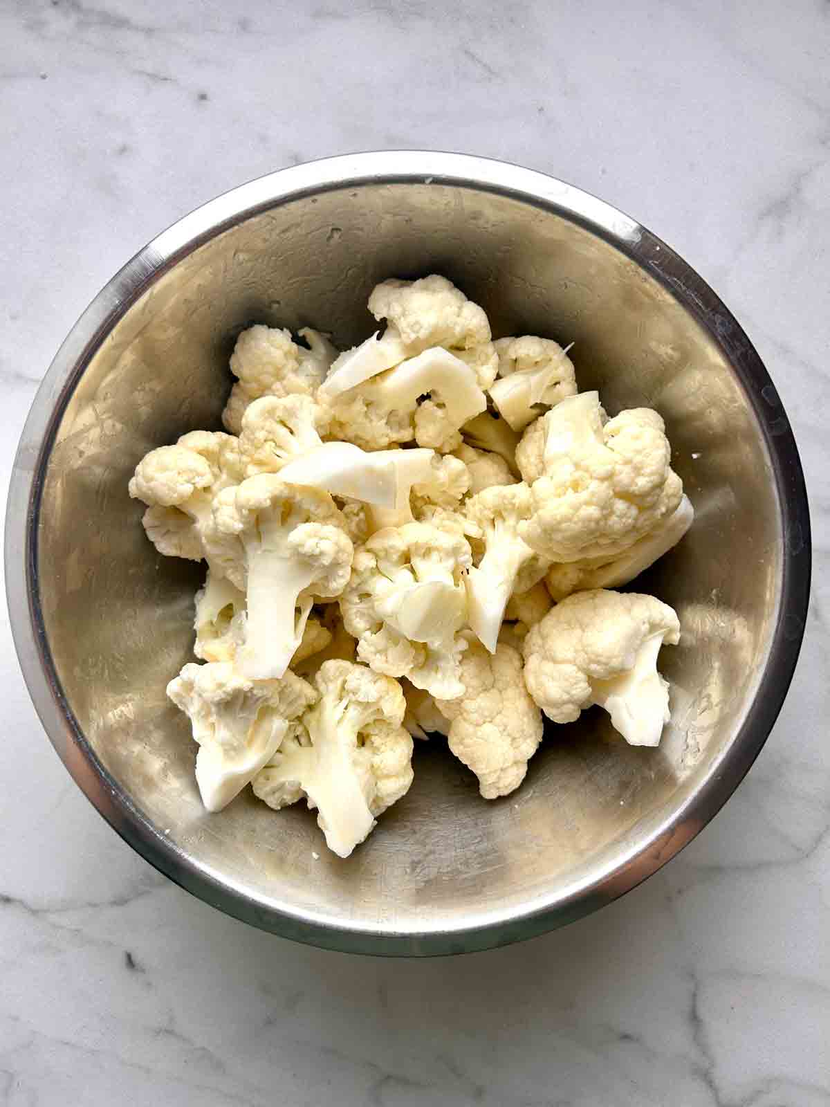 cauliflower mixed with oil in bowl.