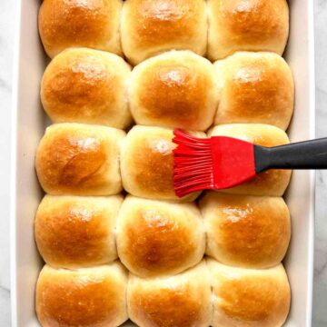 brushing butter onto baked rolls.