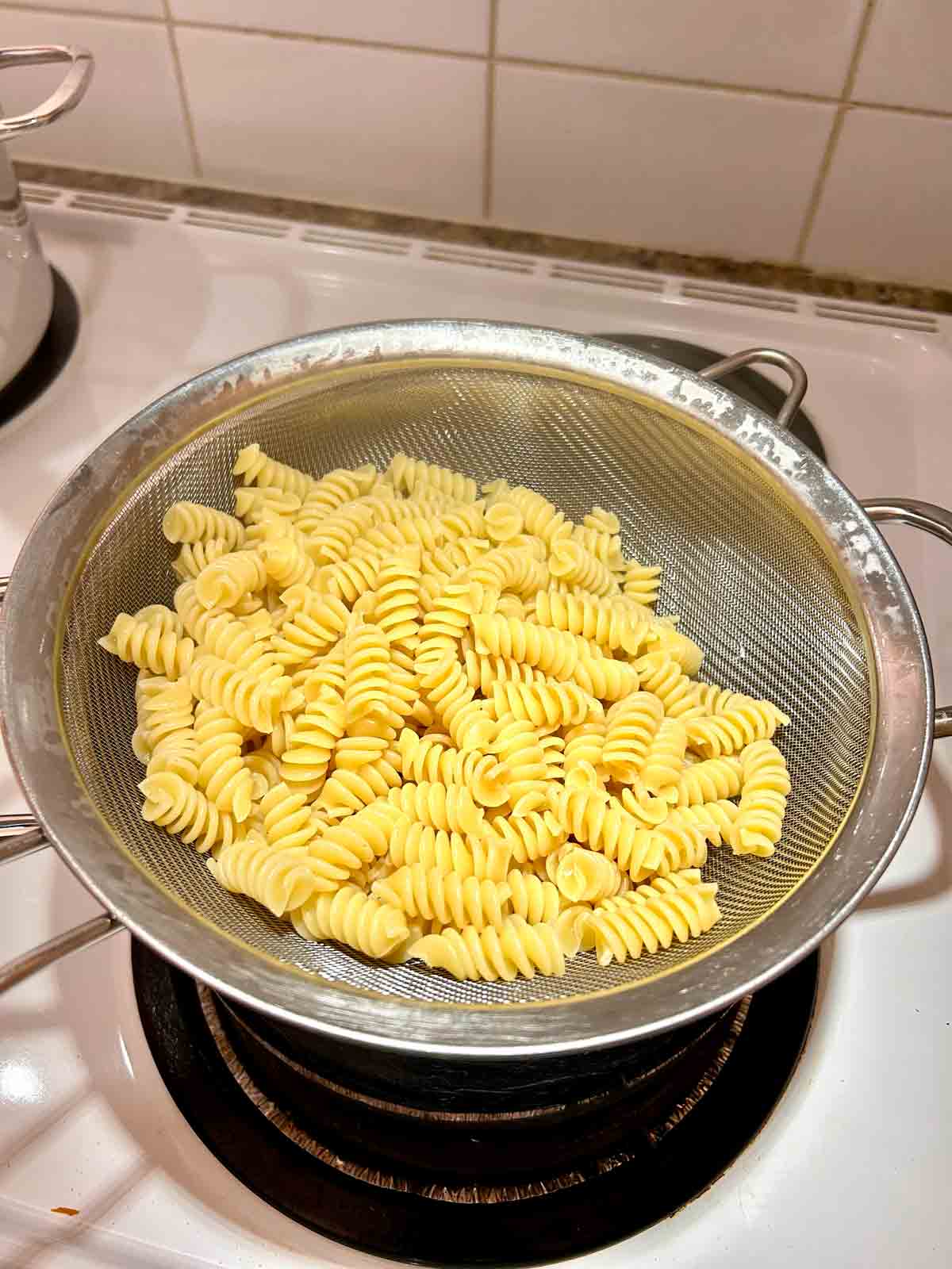 cooked pasta draining in pot.