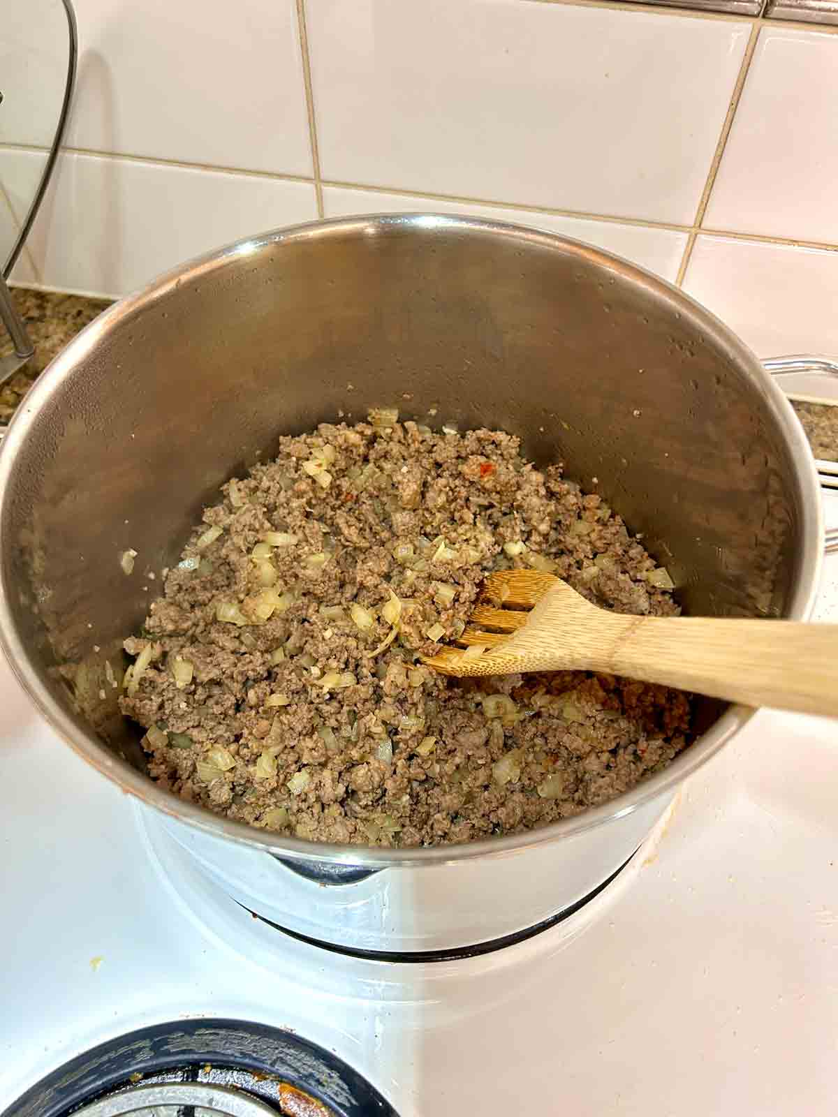 beef, onions, and garlic cooked in pot.