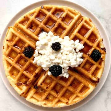 plate of cottage cheese waffles with cottage cheese and blackberries on top.