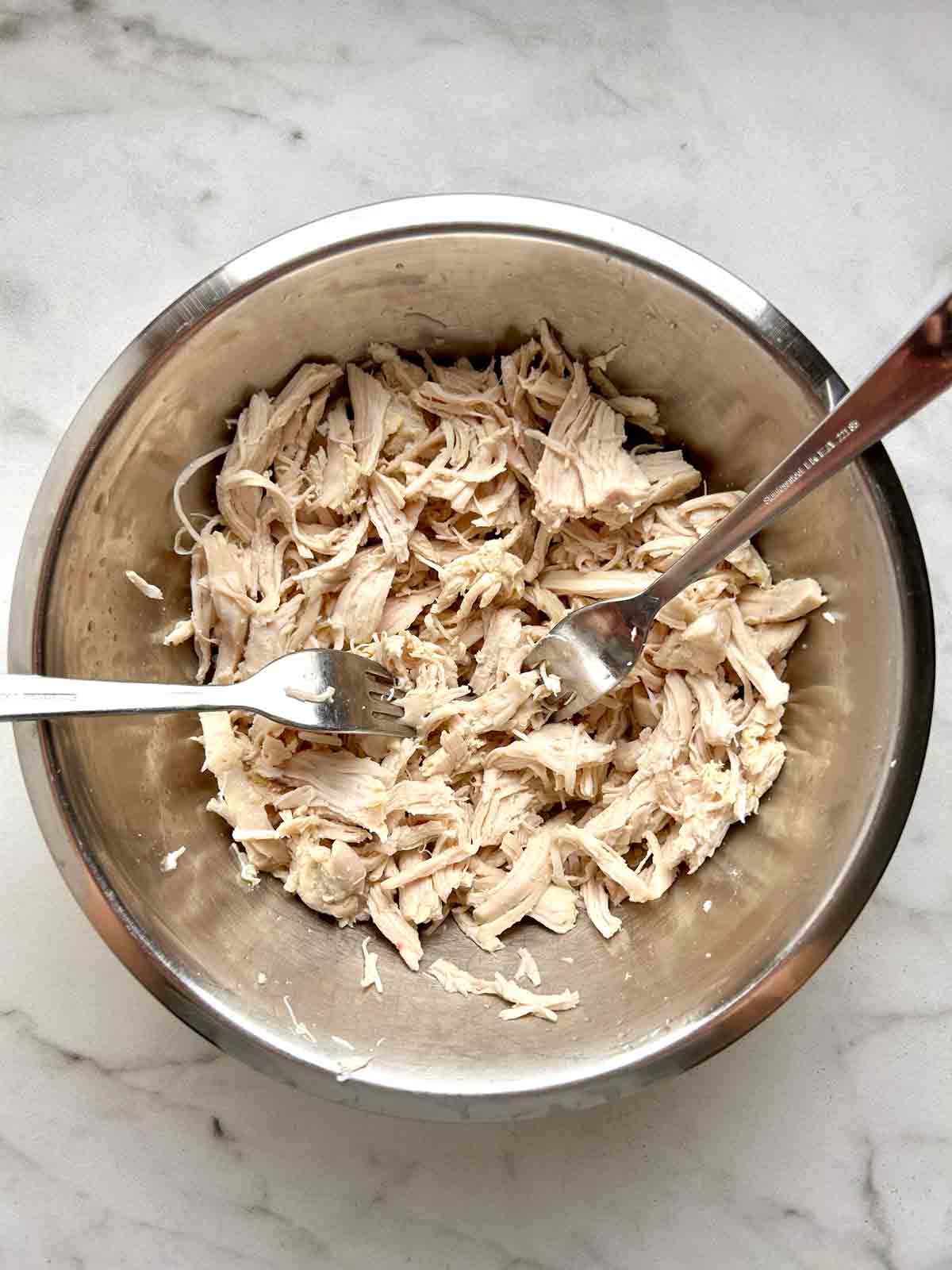 chicken shredded with forks in bowl.