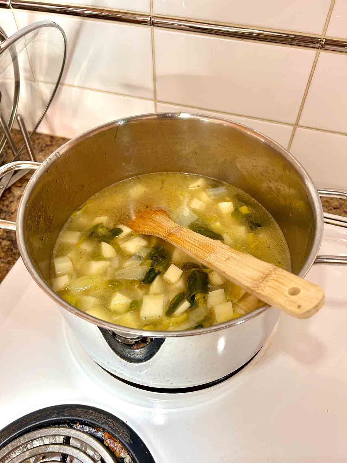 potatoes, broth, and seasonings added to pot.