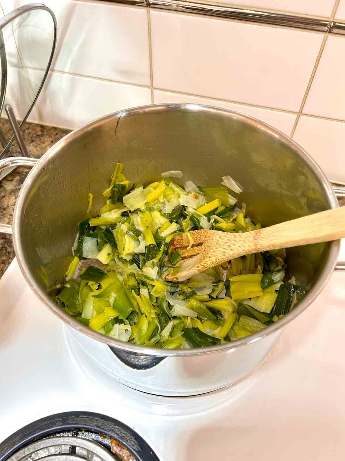 leeks being sautรฉed in pot.