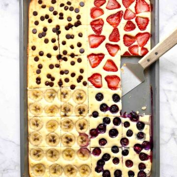 sheet pan pancakes cut into slices with spatula on pan.