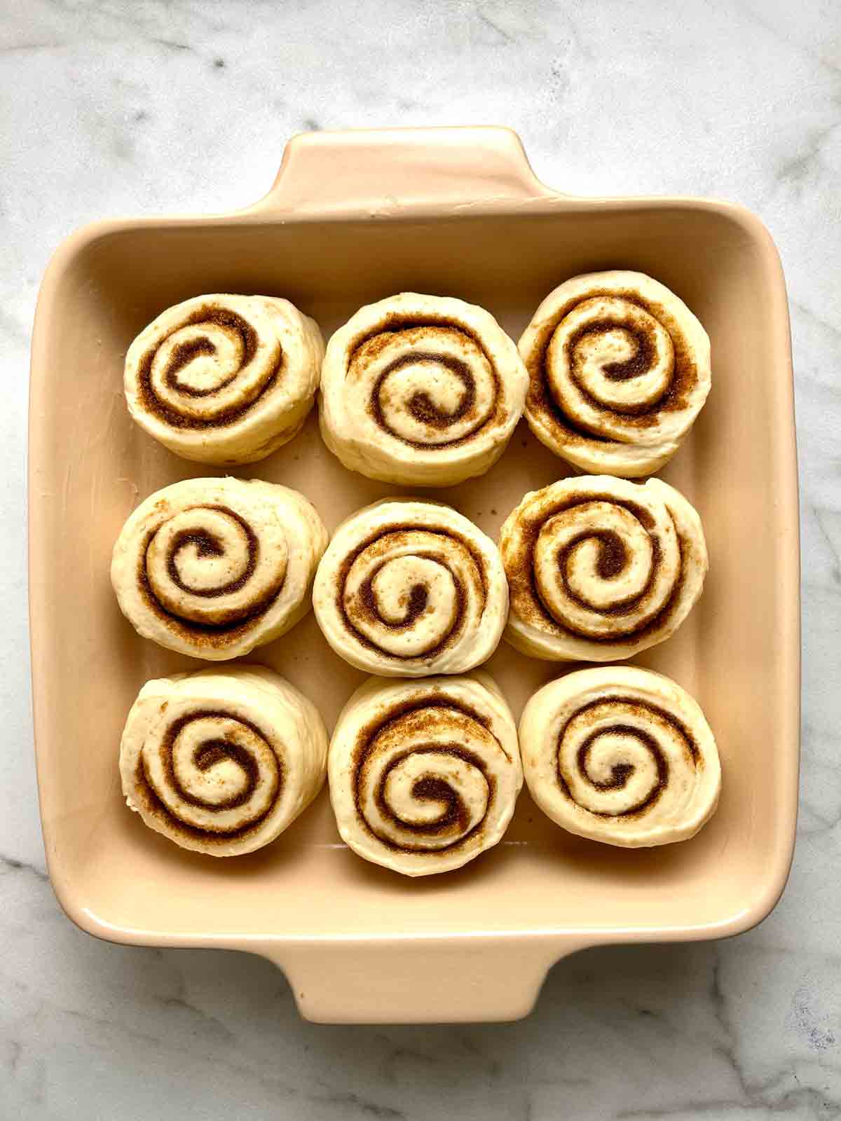 cinnamon rolls cut and arranged in baking dish.