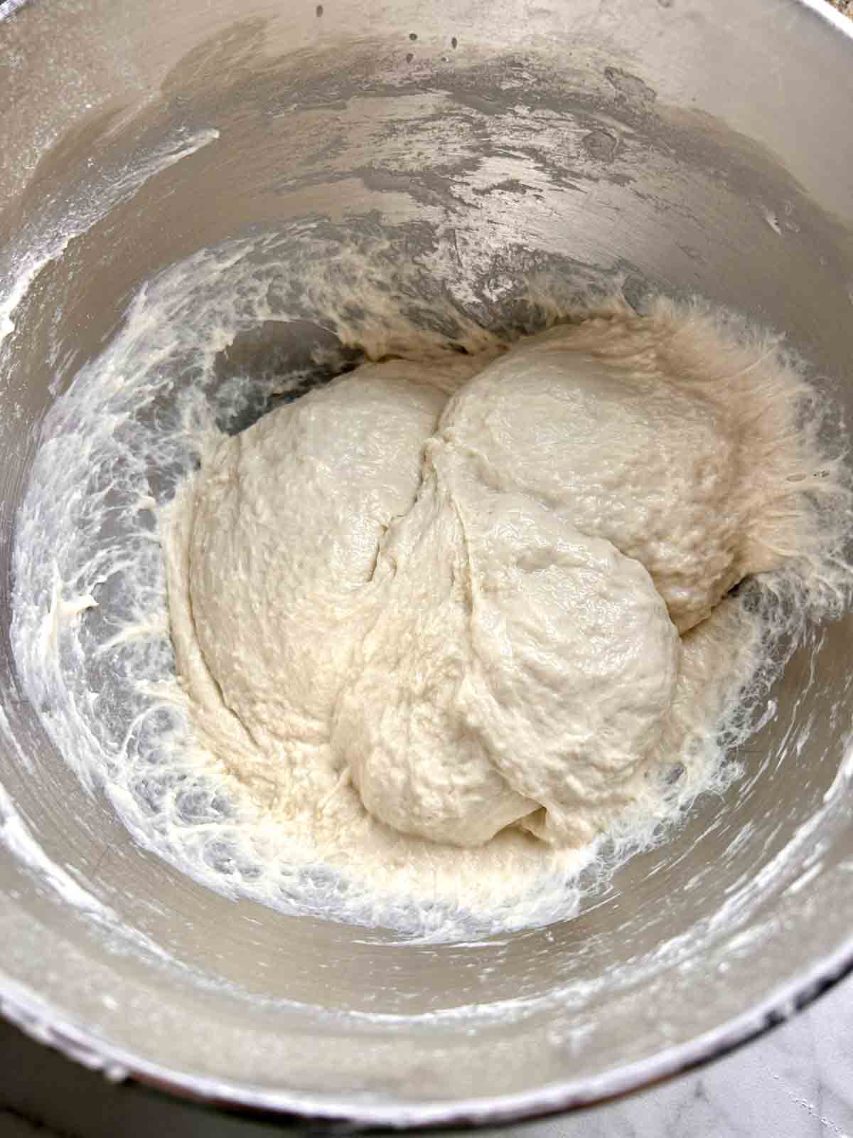 wet dough kneaded in stand mixer bowl.