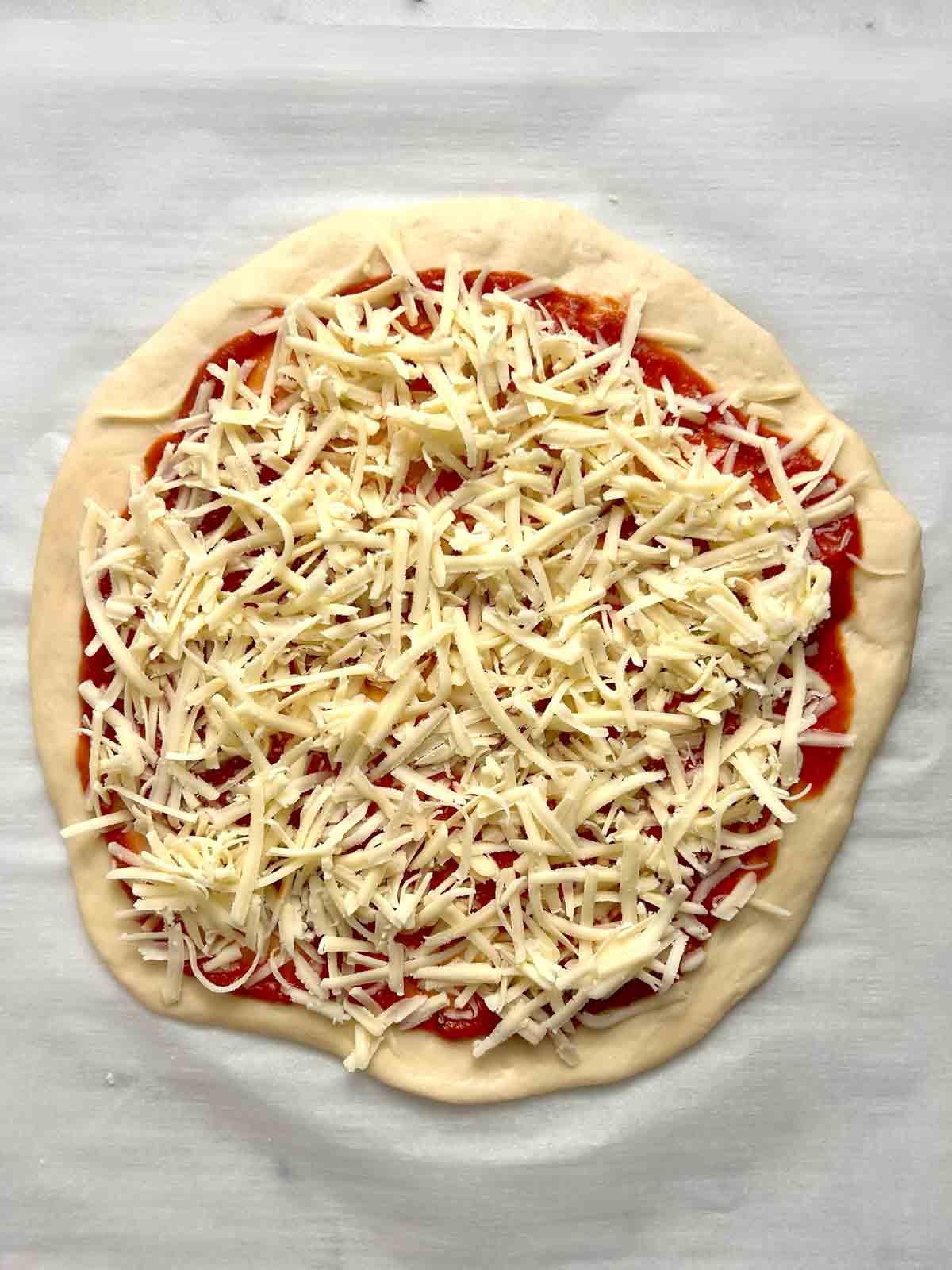 pizza sauce and toppings added to crust.