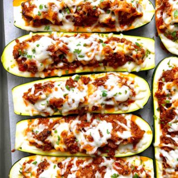 close up of stuffed zucchini boats on baking sheet.