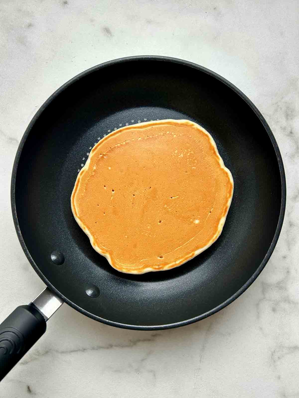 second side of pancake being cooked to golden brown.