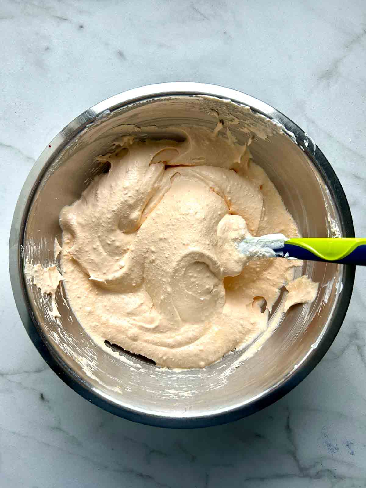Jell-O powdered mixed with Cool Whip in bowl.