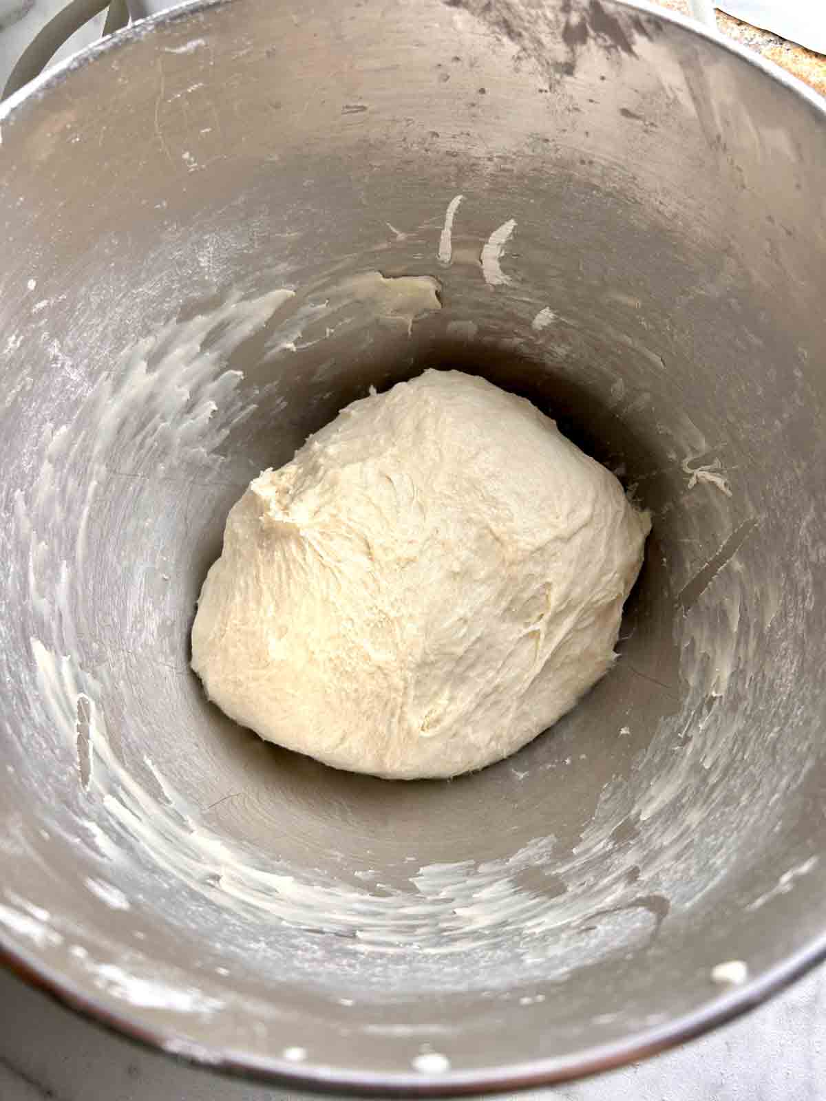 dough kneaded in stand mixer bowl.
