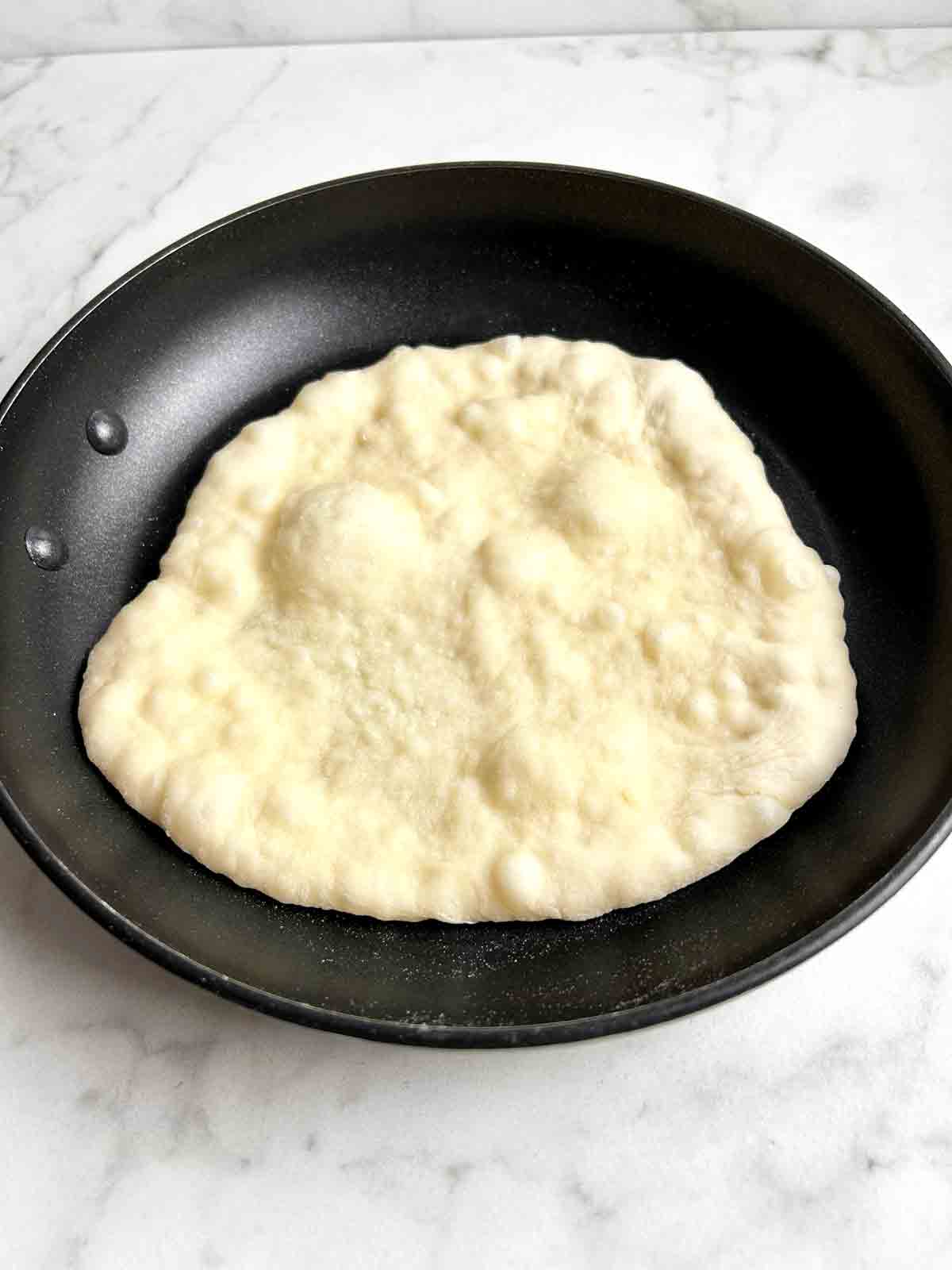 naan developing bubbles after first side being cooked.