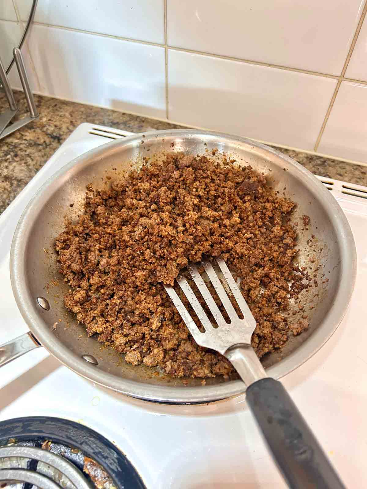 ground beef mixed with taco seasoning in skillet.