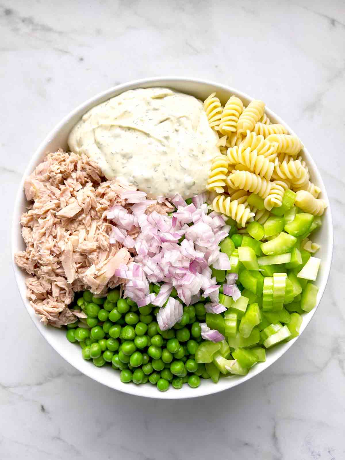 all salad components in bowl, ready to be mixed.
