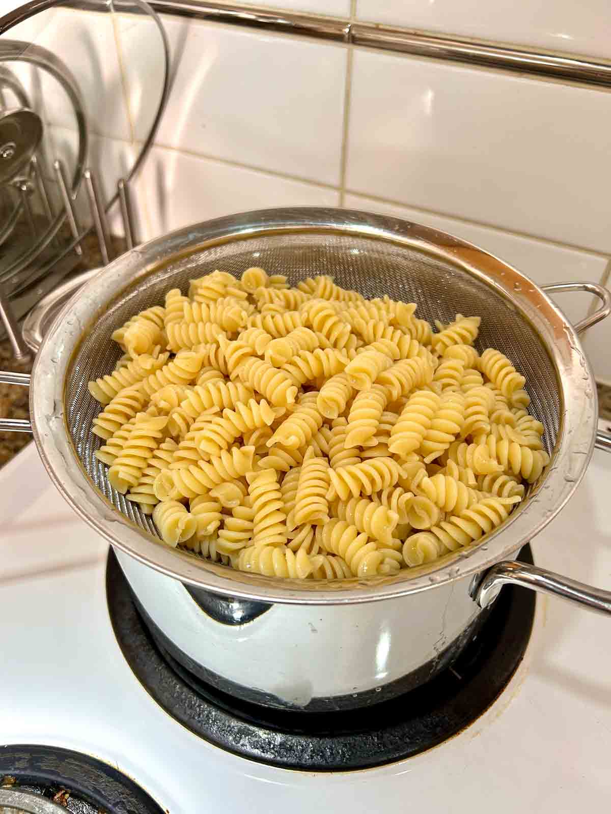 cooked pasta draining in colander.
