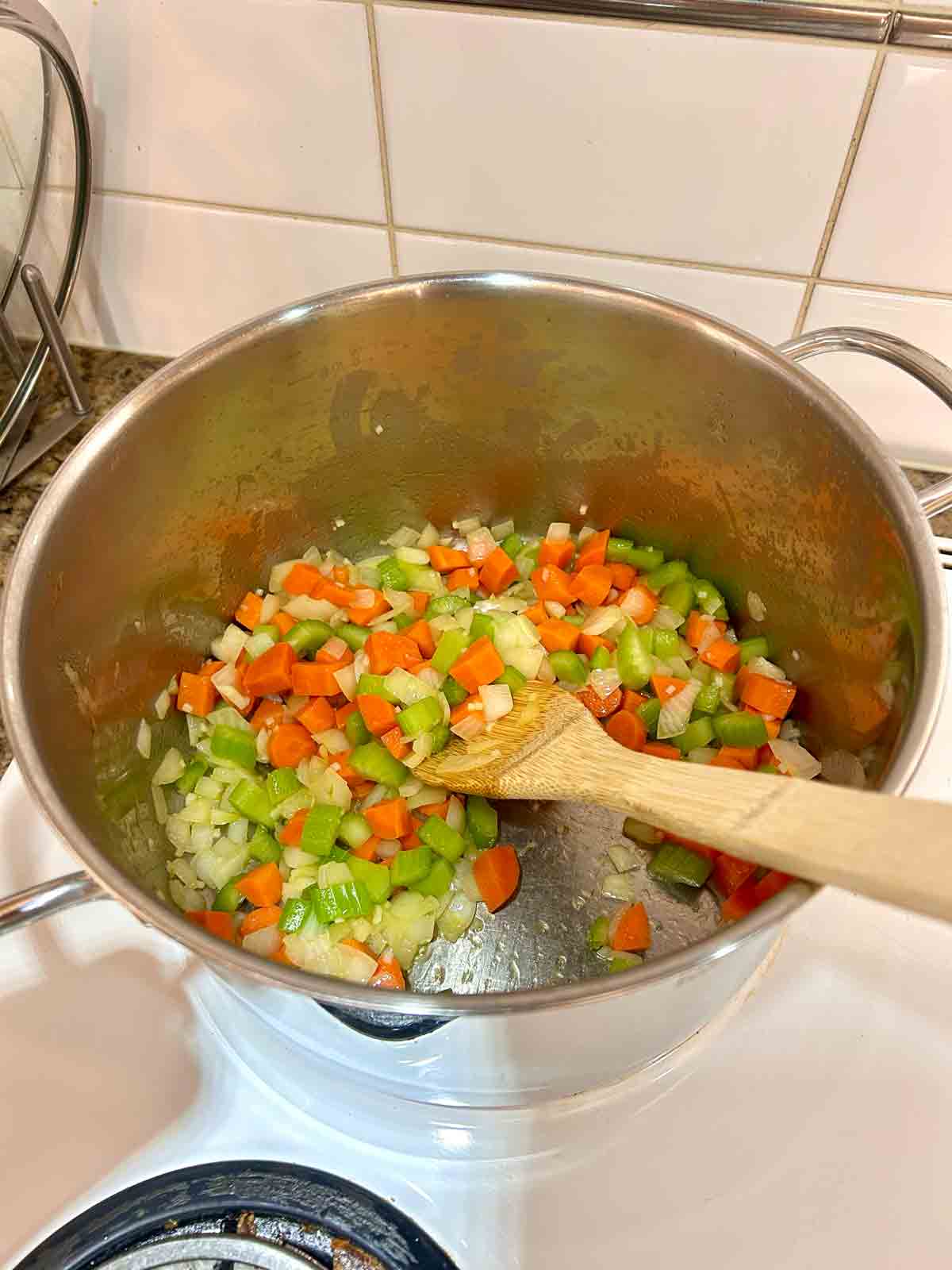 vegetables being sautéed in pot.