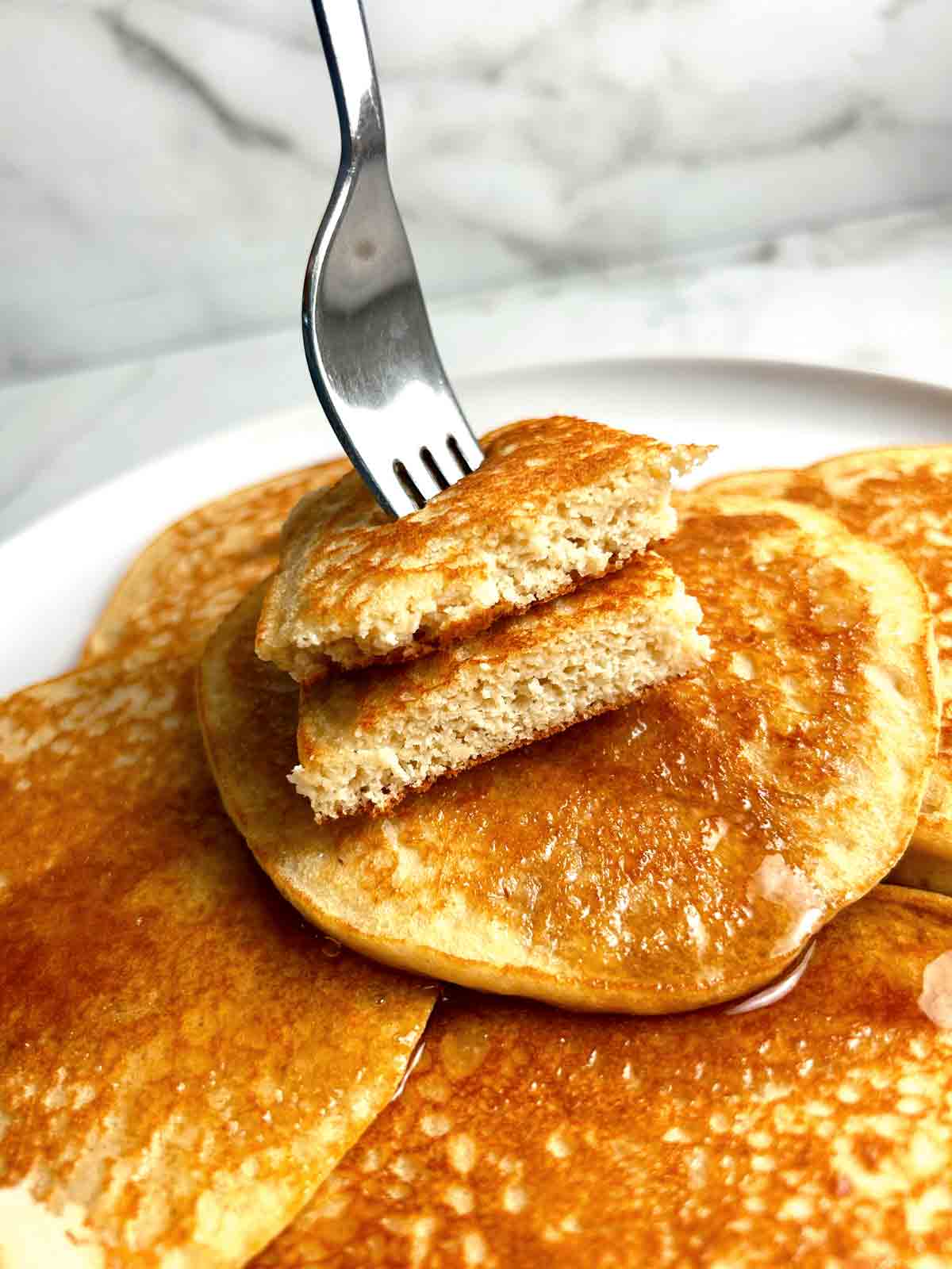 fork poking through two pieces of a almond flour pancake.