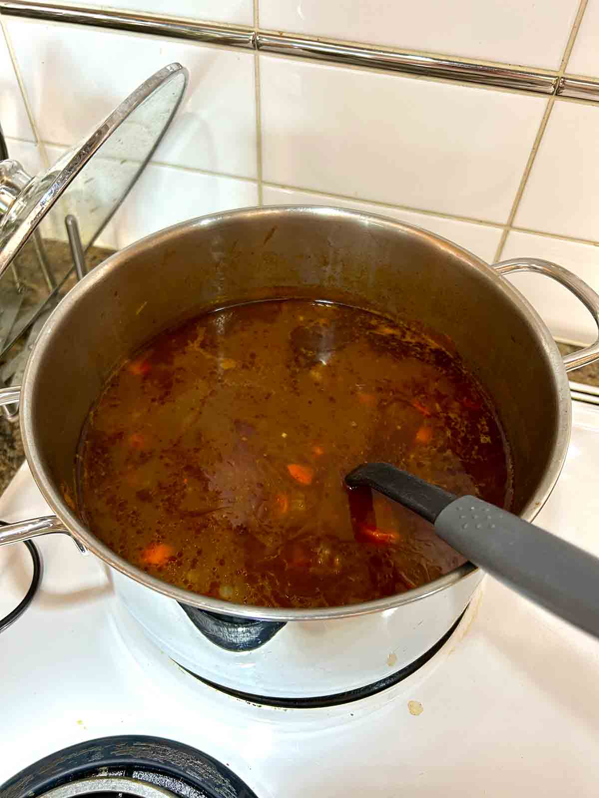 broth and beef added to pot.