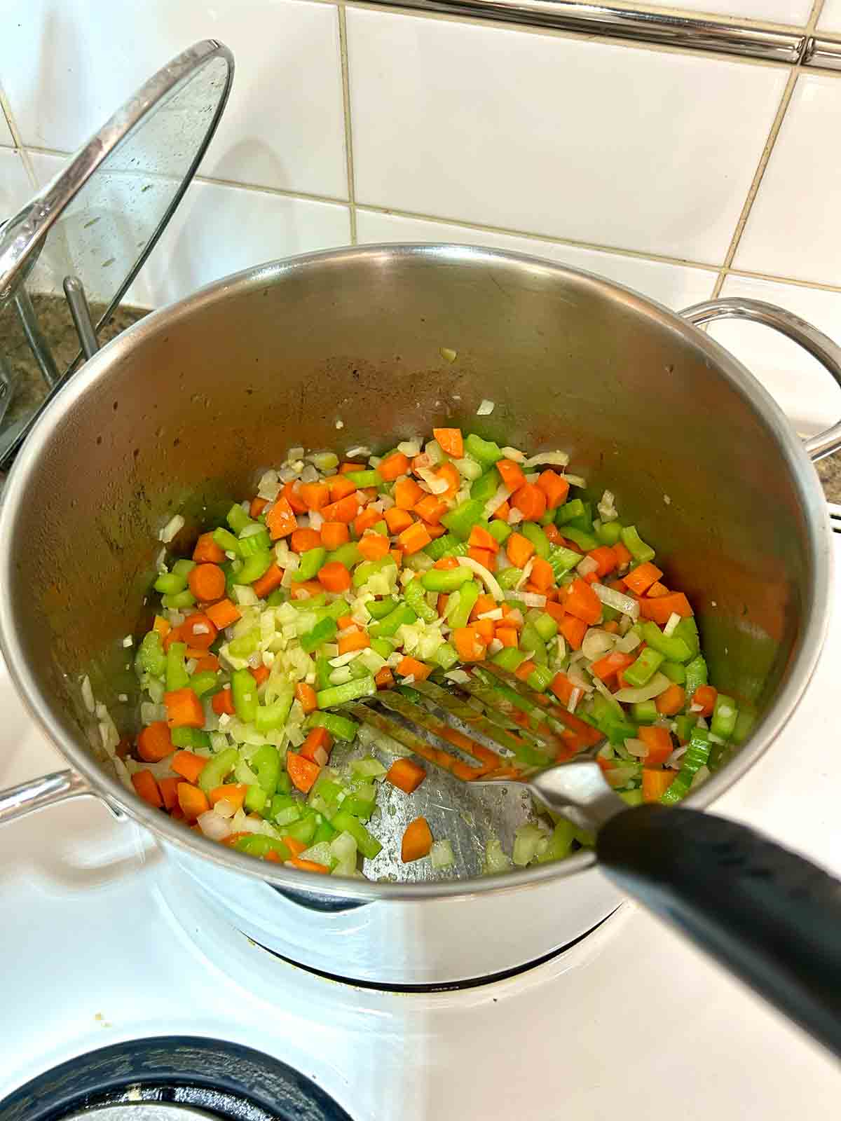 vegetables being sautรฉed in pot.