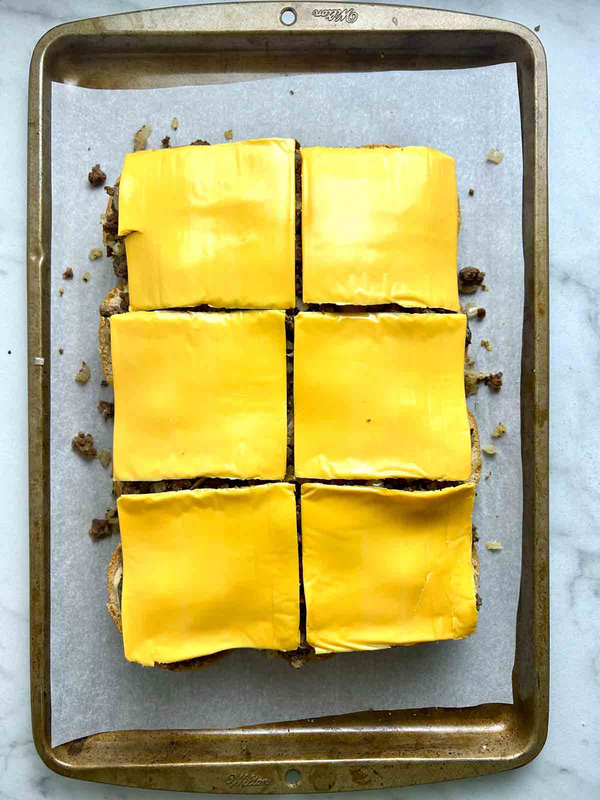 cheese slices added on top of beef.