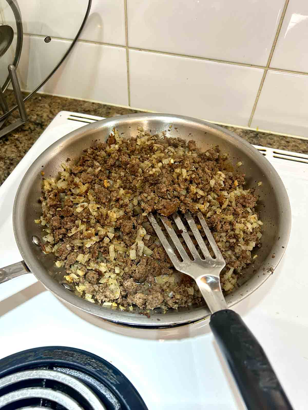 beef and onion mixture cooked in pan.