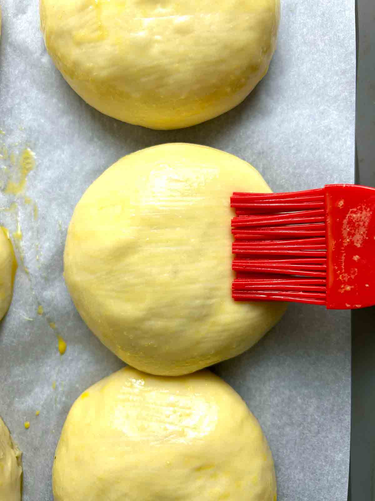 brushing egg wash on dough.