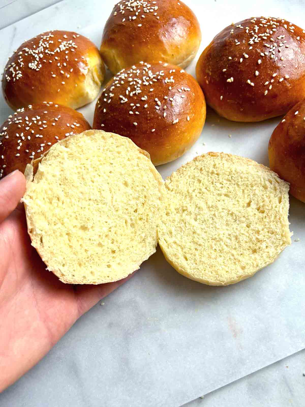 hand holding hamburger bun cut in half.