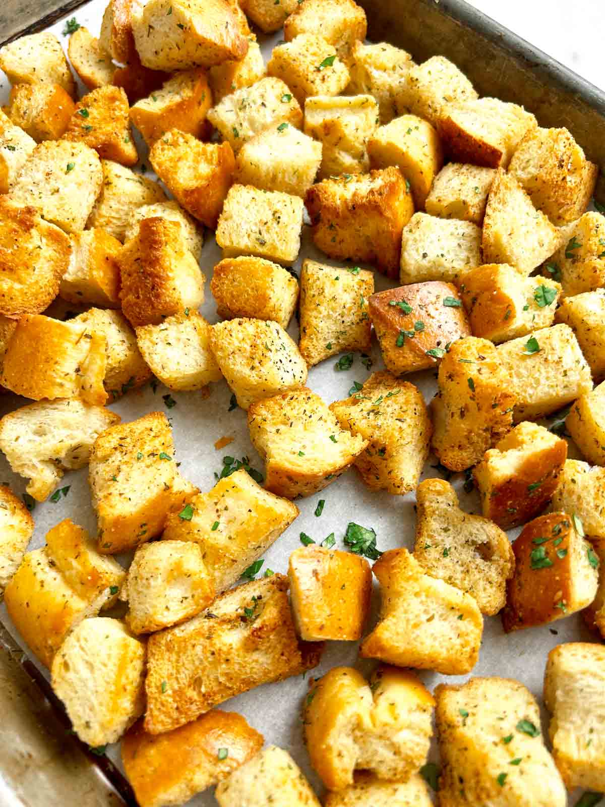 close up of homemade croutons on baking sheet.
