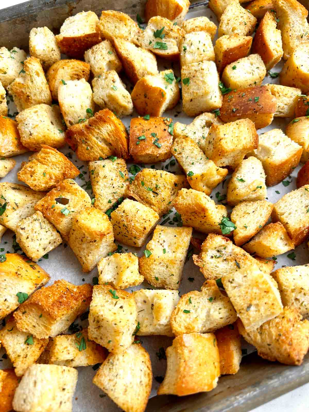 close up of homemade croutons on baking sheet.