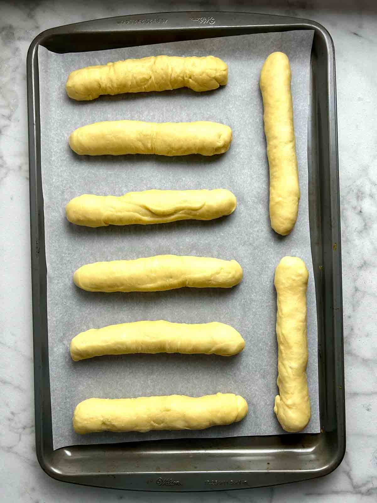 dough rolled into cylinders and placed on parchment-lined baking sheet.