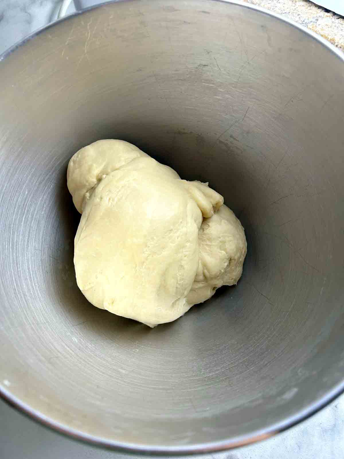 dough kneaded in stand mixer bowl.