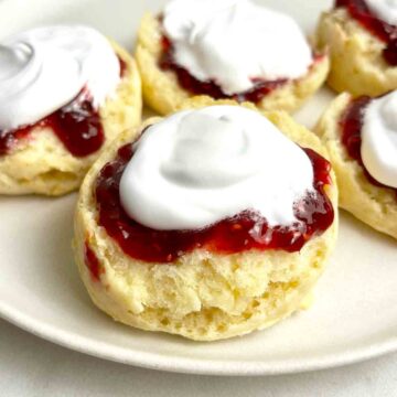 scones cut in half and topped wth jam and cream.