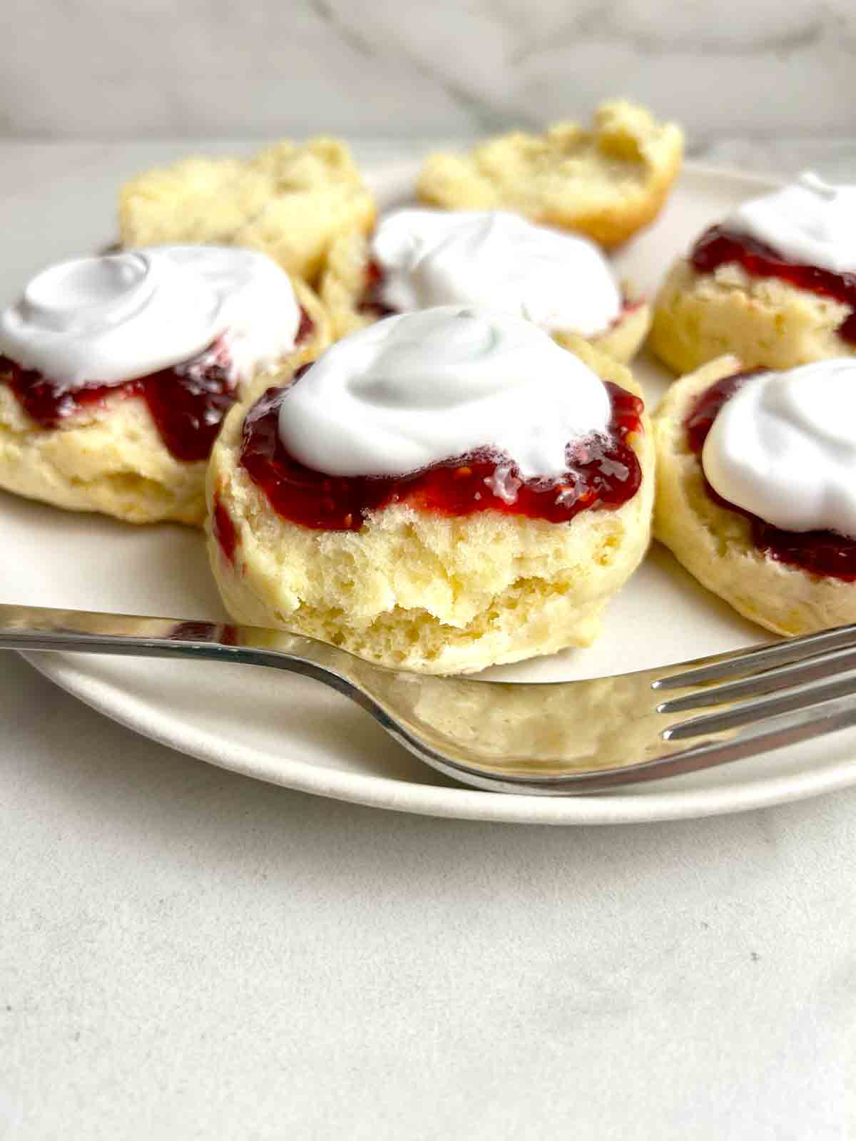 scones cut in half and topped wth jam and cream.