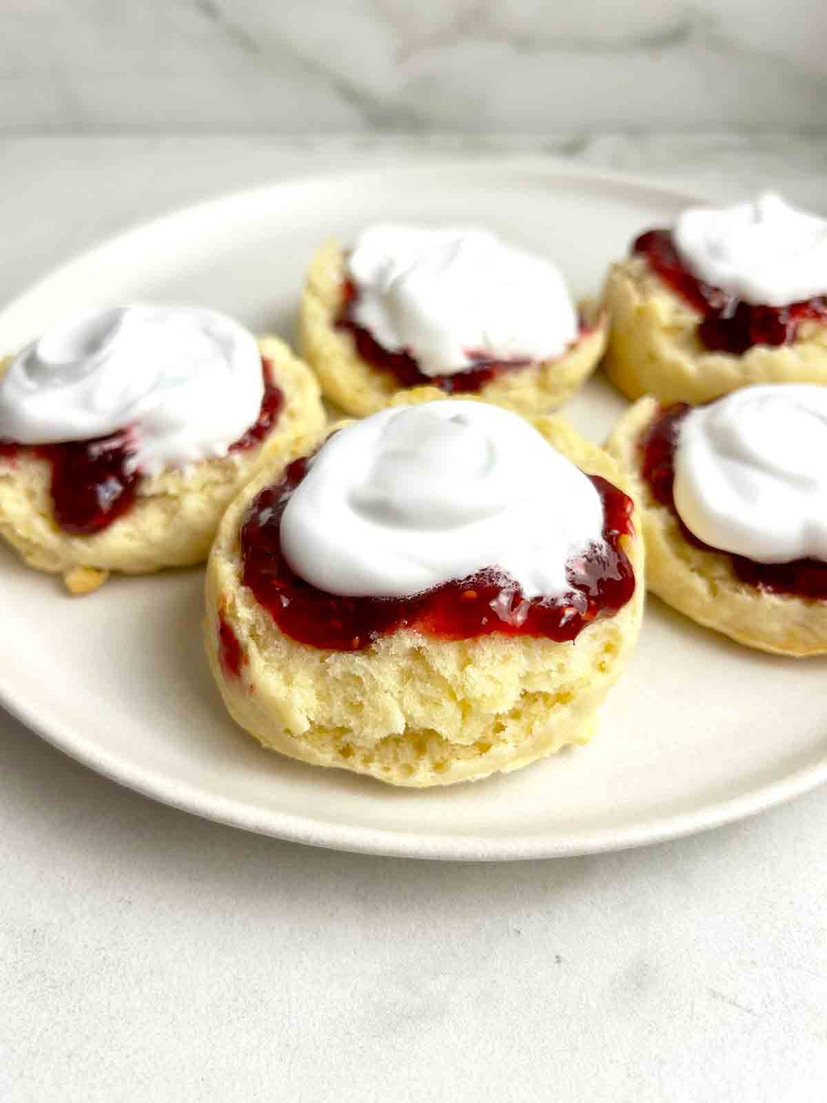 scones cut in half and topped wth jam and cream.