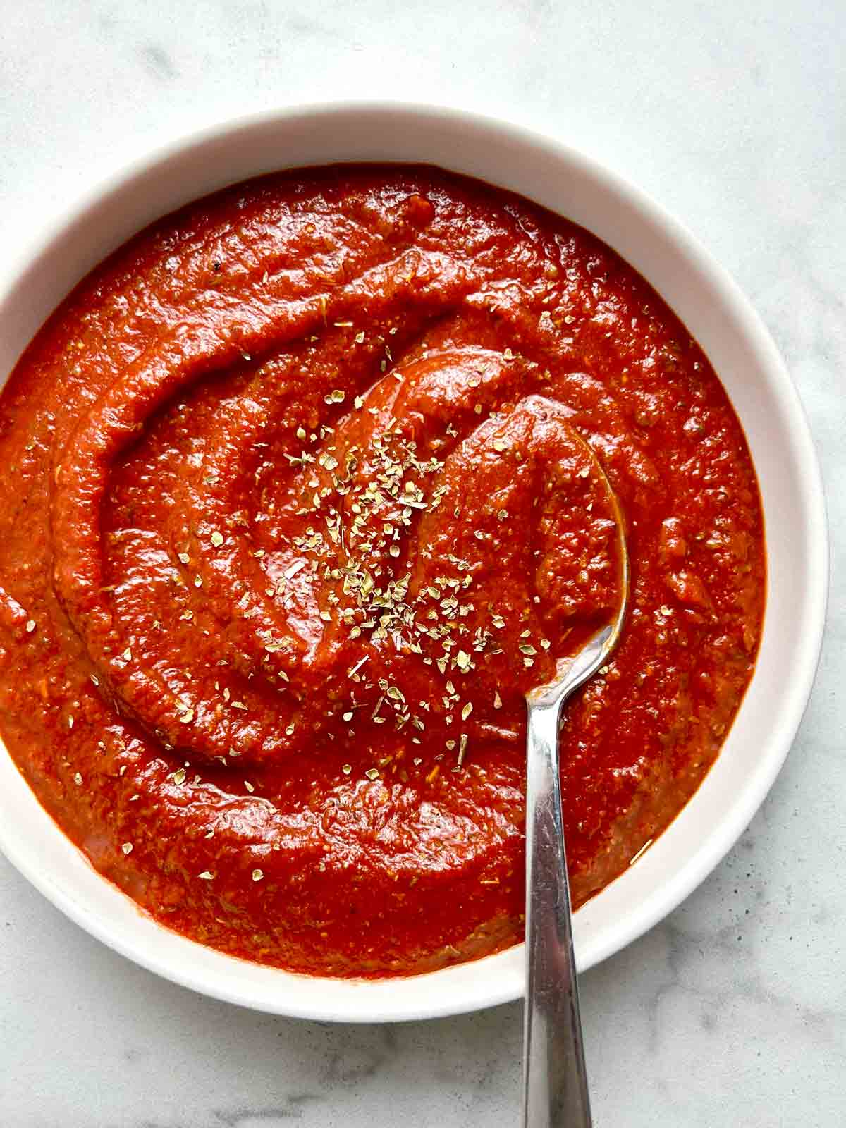 pizza sauce in bowl with spoon.
