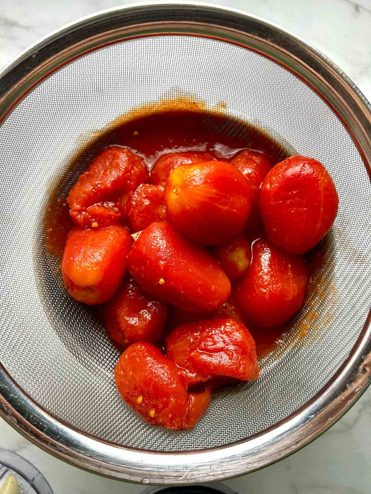 tomatoes straining over bowl.