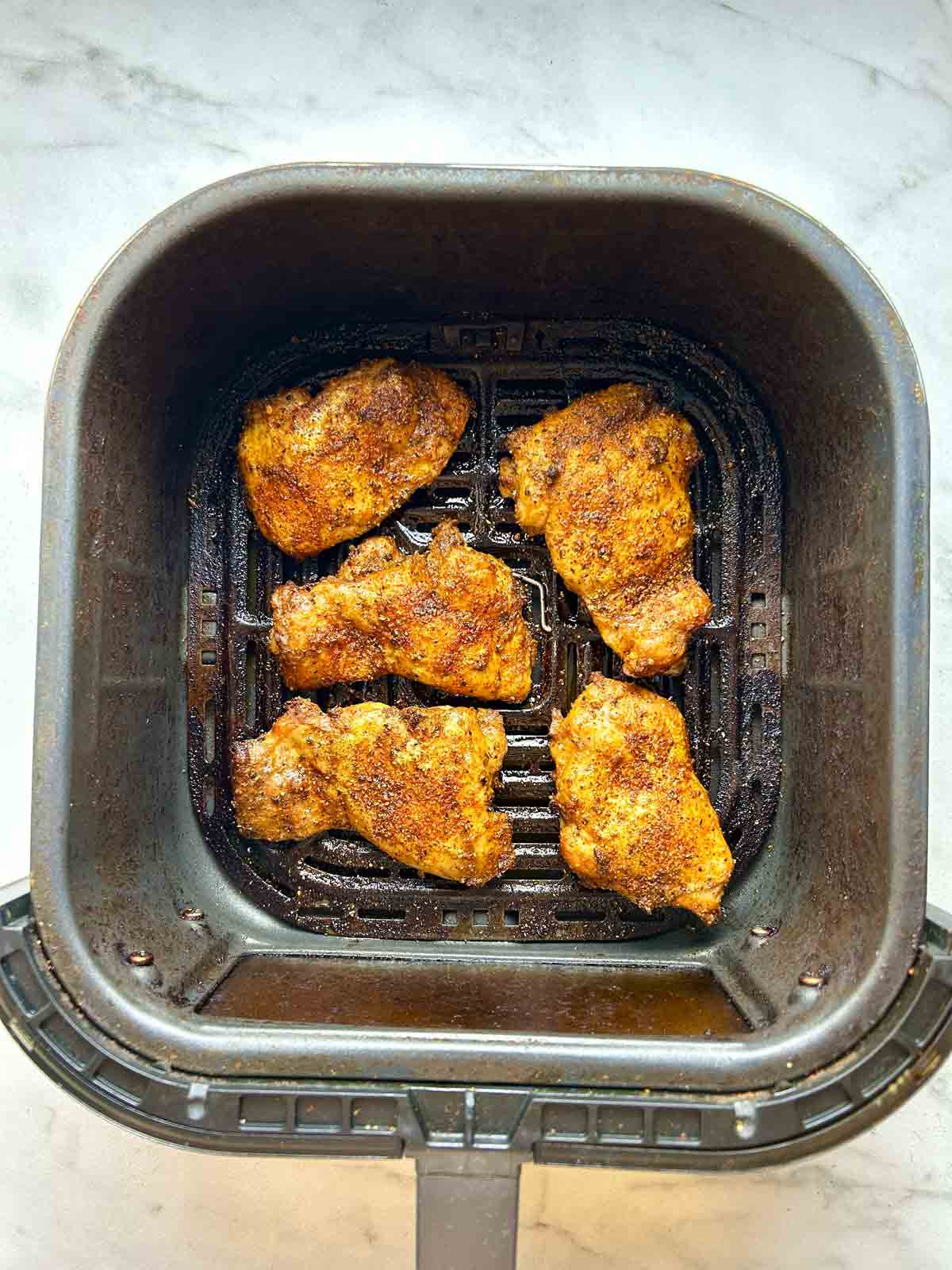 chicken thighs after air-frying; golden brown and crisp.