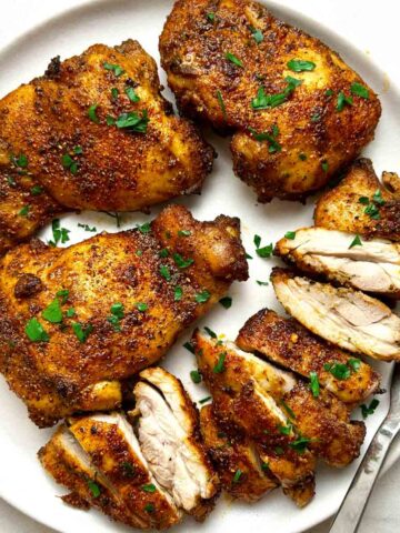 plate of air-fried chicken thighs; some are cut into pieces.