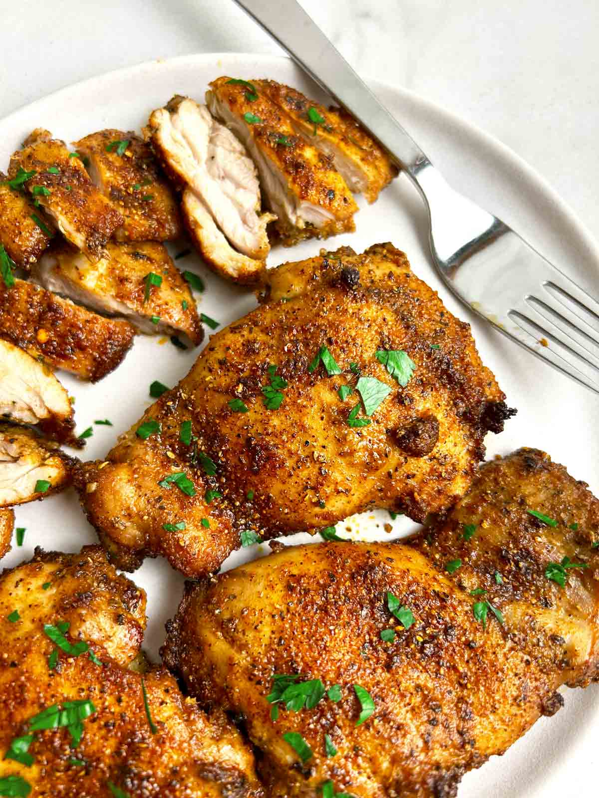 close up of air-fried chicken thighs on plate.