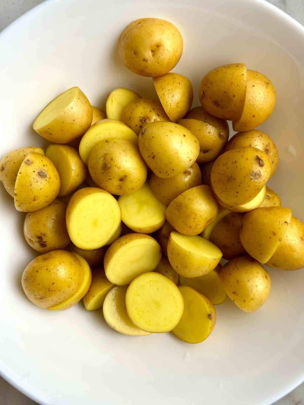 baby potatoes halved in bowl.