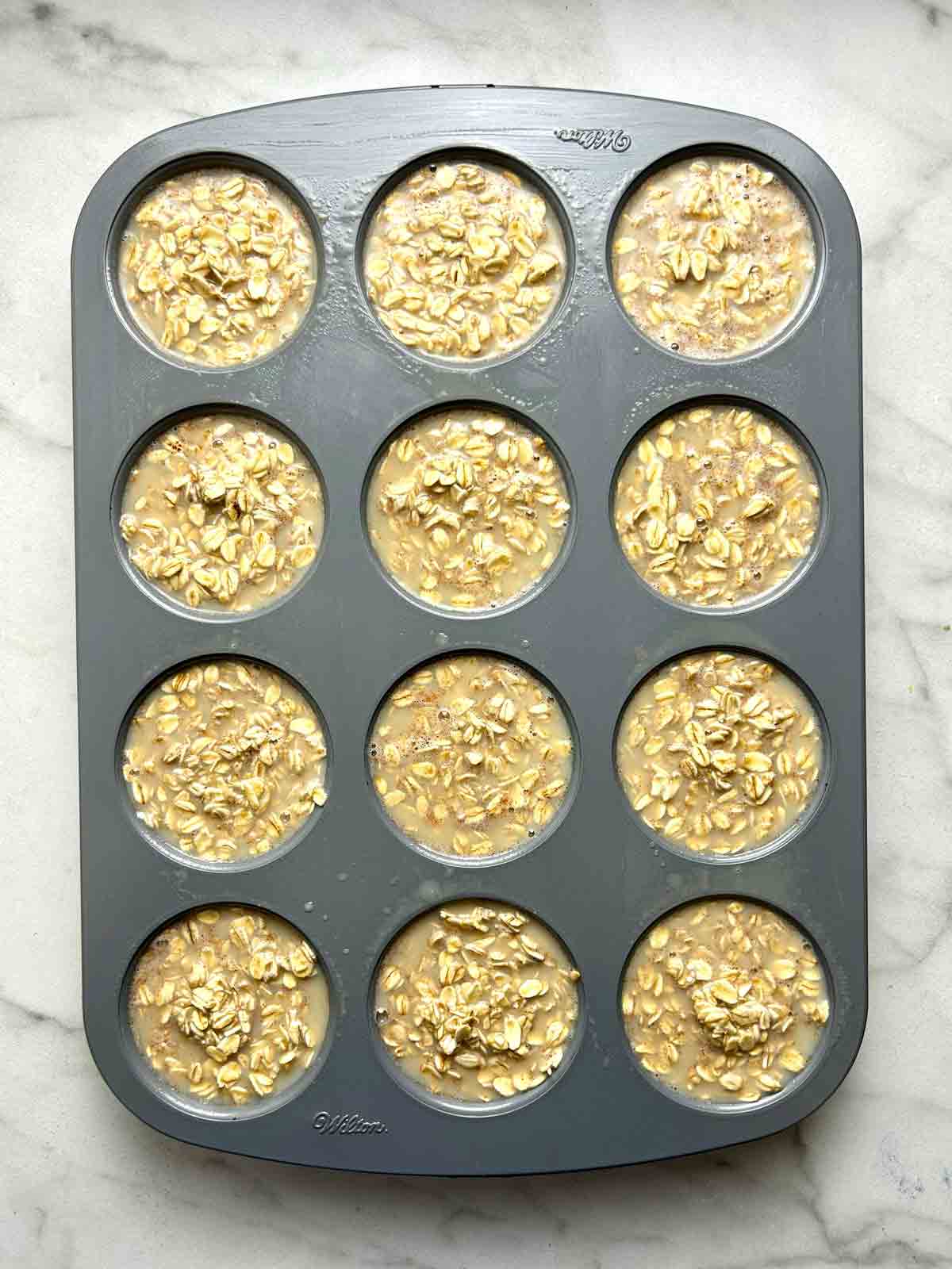 oatmeal batter divided into muffin pan.