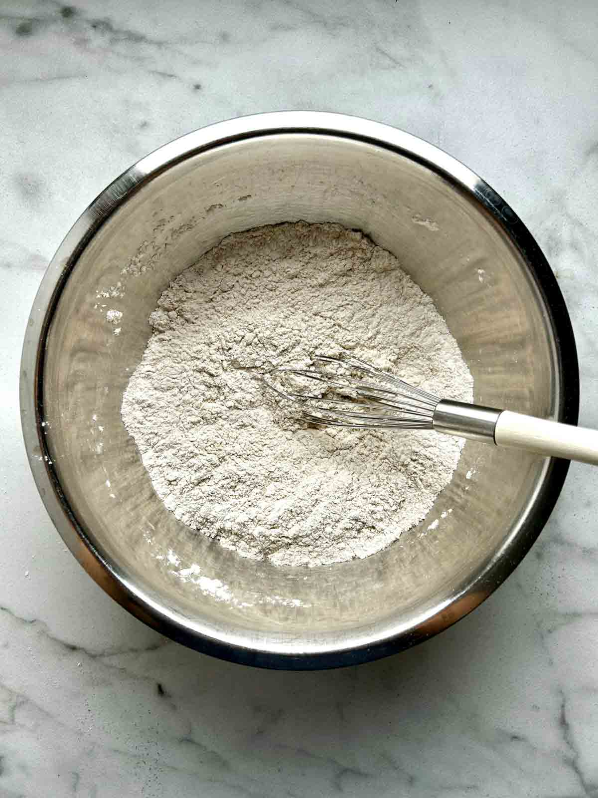flour mixture whisked in metal bowl.