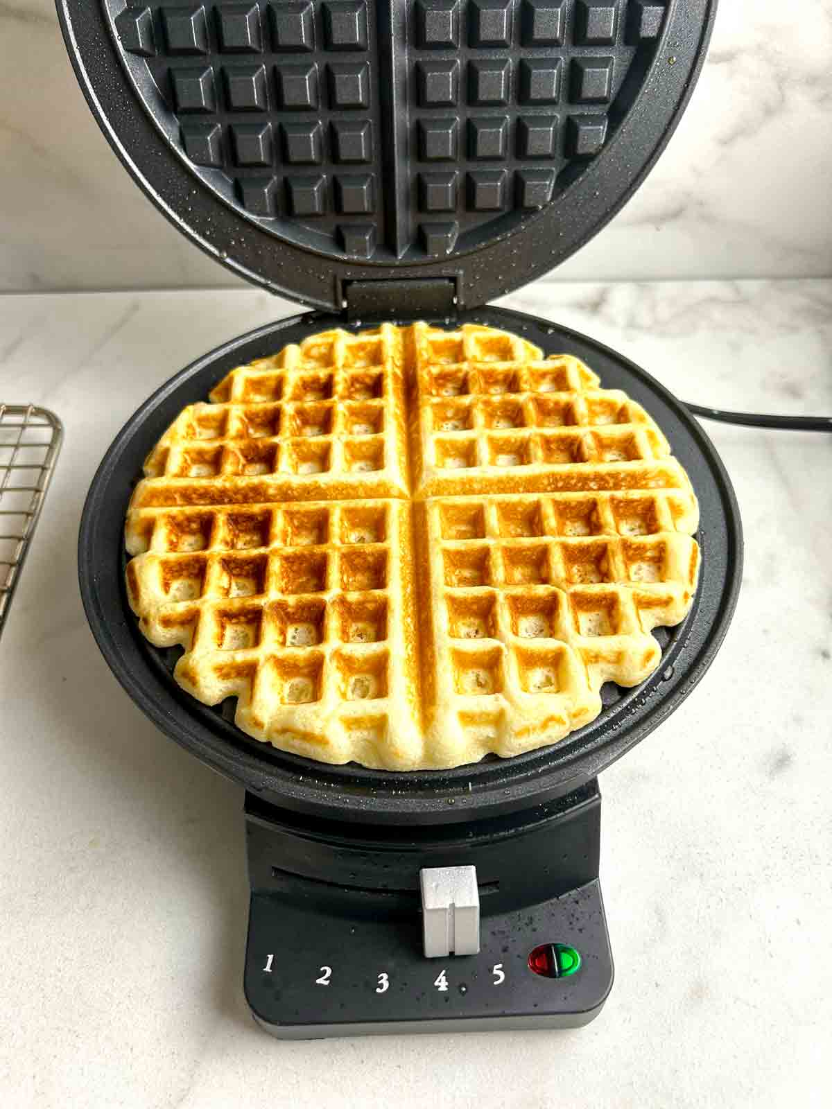 golden brown waffle in waffle iron.