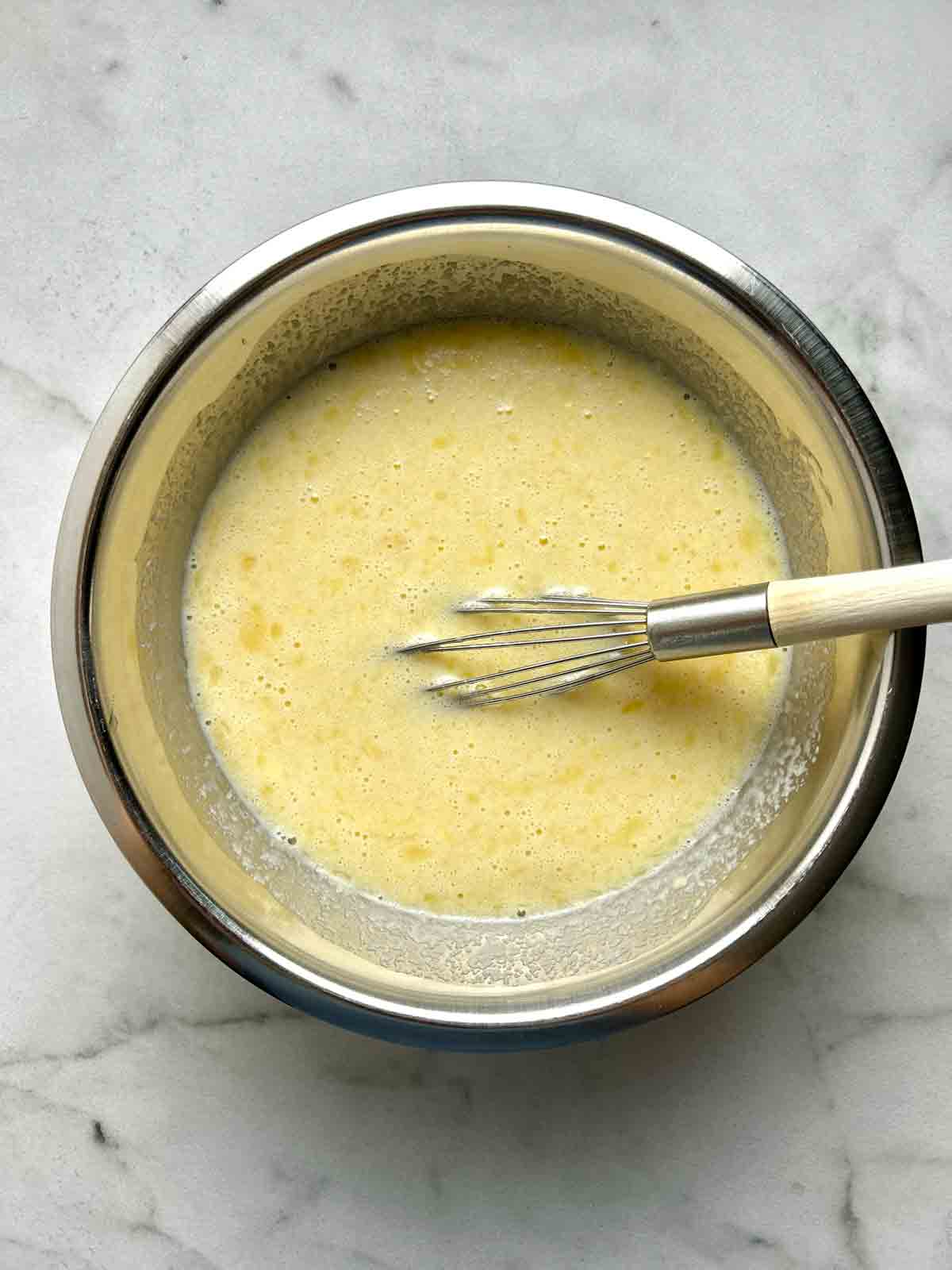 wet ingredients whisked in metal bowl.