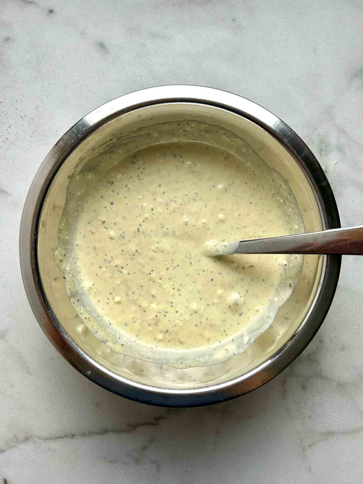 dressing mixed in metal bowl.