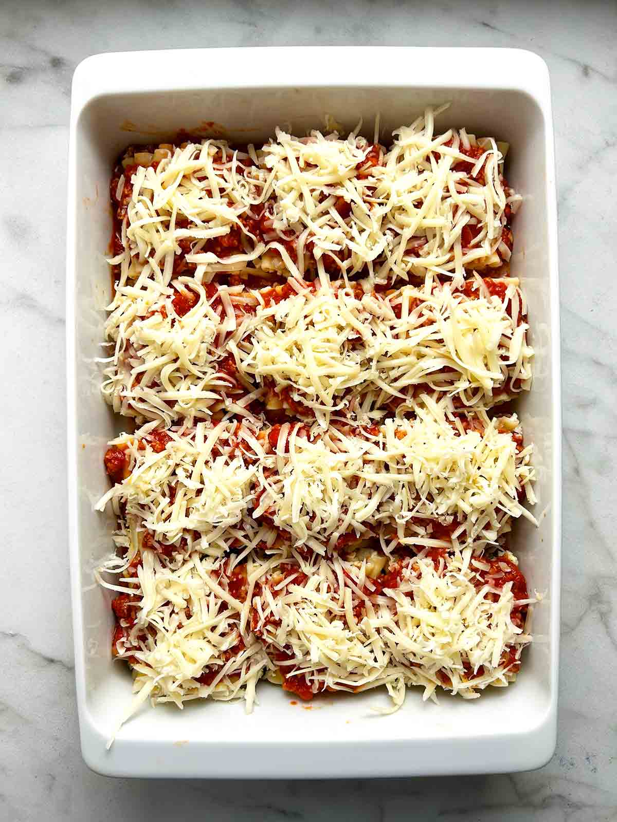 shredded mozzarella sprinkled on top of meat sauce.