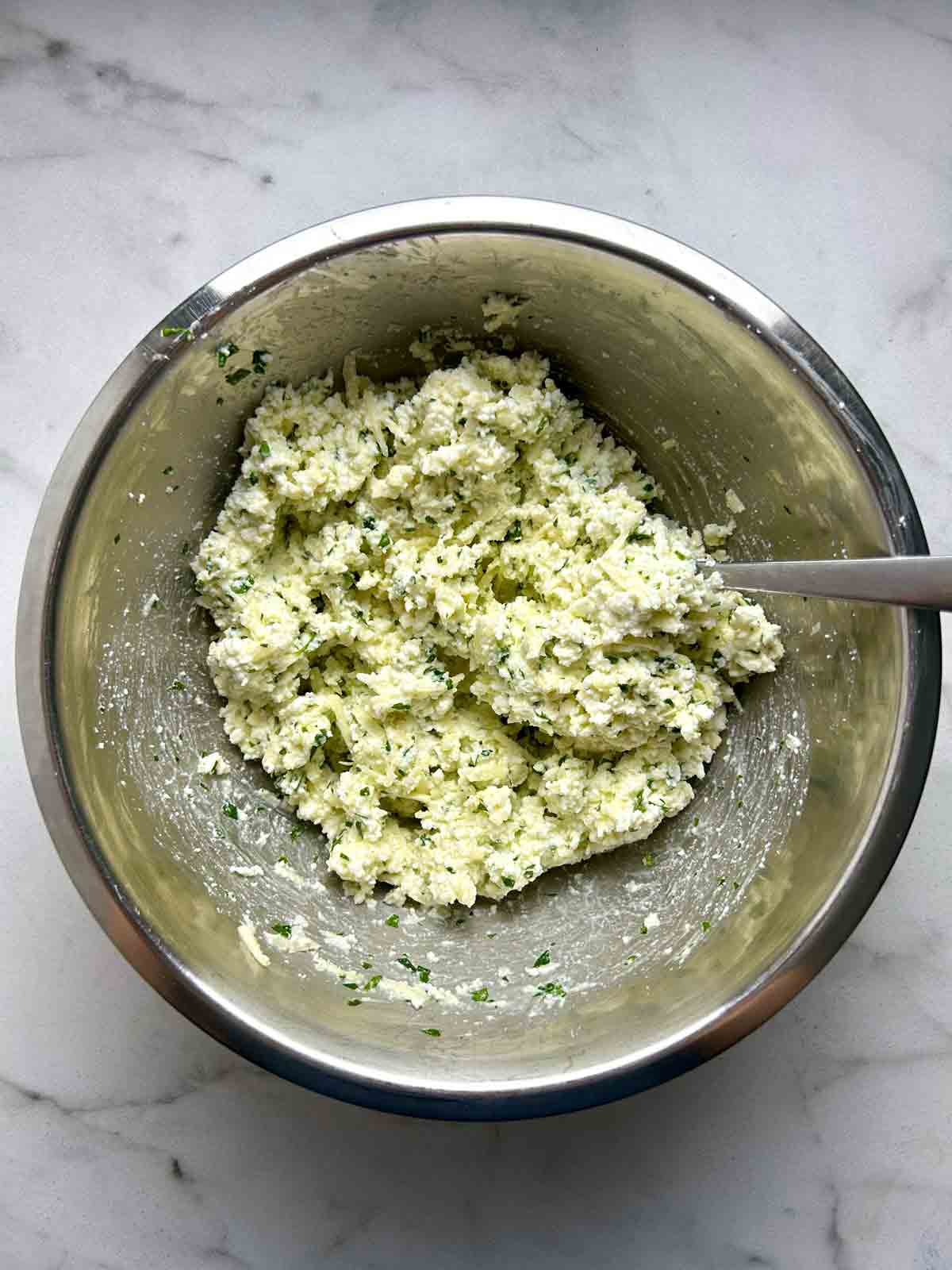 ricotta filling being mixed in metal bowl.